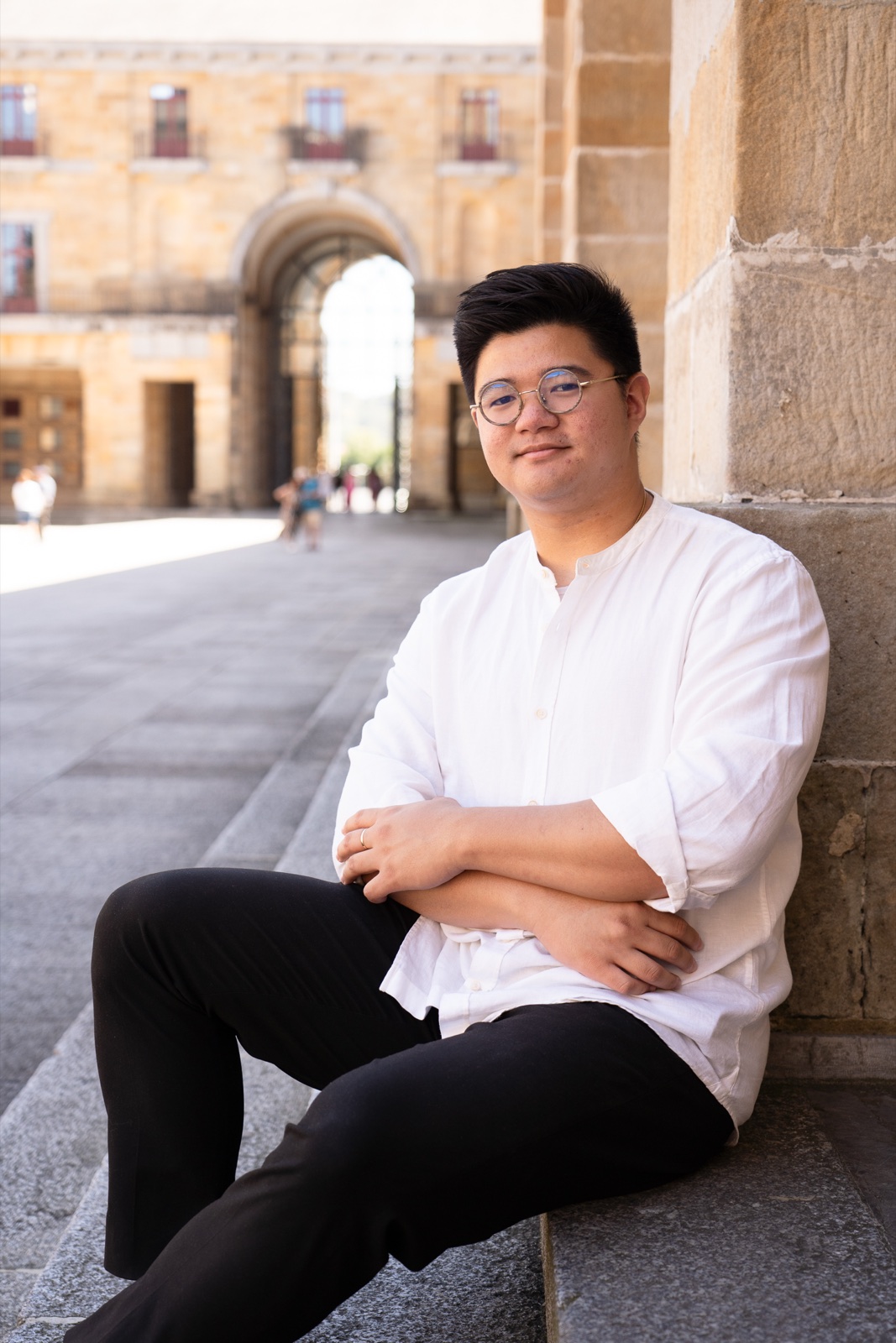 Stephen Joven-Lee seated beneath the portico in Gijón, Spain